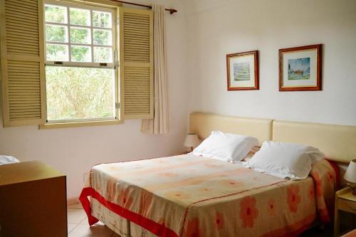 Un dormitorio con una cama grande con ventana. en Pousada Solmaior, en Conservatória