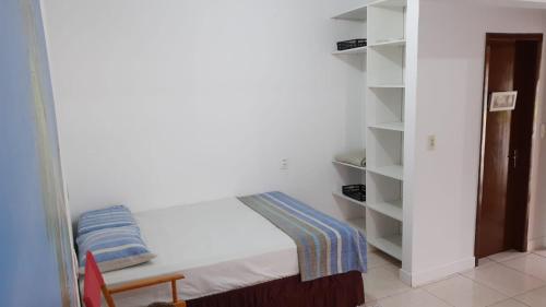 伊塔佩马FLAT Promoção Mensal的小房间设有床和书架