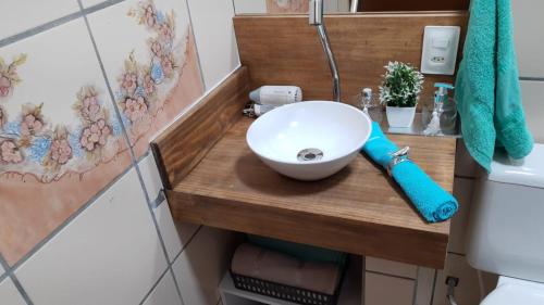 イタペマにあるFLAT Promoção Mensalのバスルーム(白いボウルシンク付きの木製カウンター付)