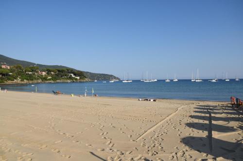 a beach with footprints in the sand and water at VILLA VILLACOLLE in Procchio