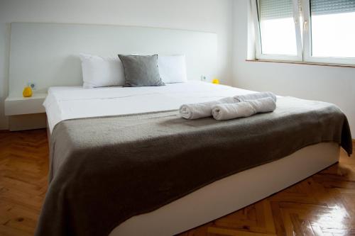 1 dormitorio con 1 cama con 2 toallas en Gevgelija Downtown Apartment en Gevgelija