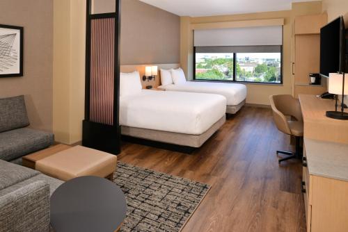 a hotel room with two beds and a couch at Hyatt Place Chicago Wicker Park in Chicago