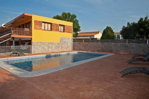 a swimming pool in front of a house at Bungalows Pascual in Vinarós