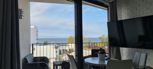 a balcony with a table and a view of the ocean at Apartament Horyzont in Międzyzdroje