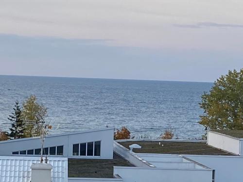 a white building with the ocean in the background at Apartament Horyzont in Międzyzdroje