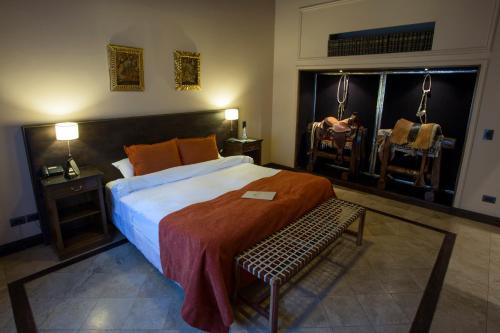 a bedroom with a large bed and two chairs at Casa La Galeana - Eco Boutique in Chacras de Coria