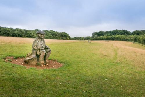 a statue of a man sitting on a rock in a field at Holiday Inn Express Folkestone Channel Tunnel by IHG in Folkestone