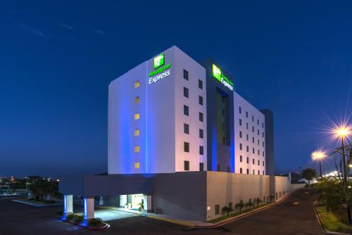 a hotel with a lit up building at night at Holiday Inn Express Guaymas by IHG in Guaymas