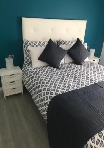 a bedroom with a bed with black and white pillows at VIP HOLIDAYS Morro Jable Beach & Center 2 in Morro del Jable
