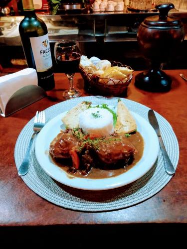 a plate of food with meat and bread on a table at hotel le Massilia in Belém