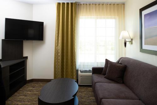 a living room with a couch and a window at Candlewood Suites Olathe by IHG in Olathe