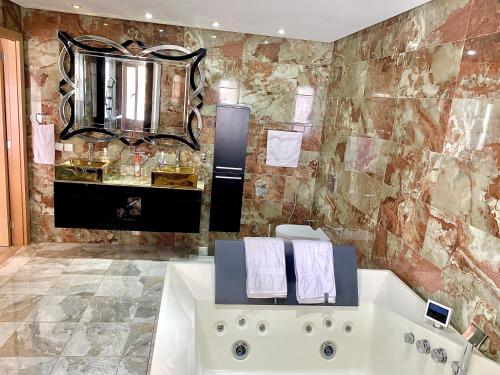 a bathroom with a tub and a sink and a mirror at Villa L&M in Salé