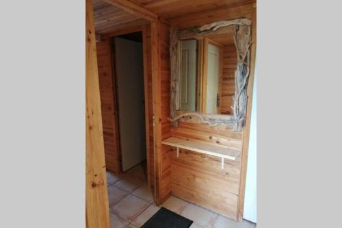 um quarto num chalé de madeira com um espelho em Studio 22 m2, terrasse vue montagne, dans propriété face au Lac du Salagou em Liausson