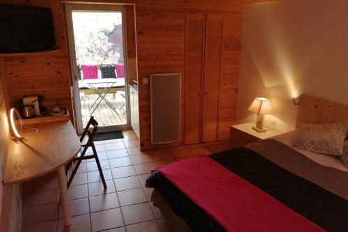 una camera da letto con un letto, una scrivania e una finestra di Studio 22 m2, terrasse vue montagne, dans propriété face au Lac du Salagou a Liausson