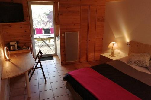 Liausson的住宿－Studio 22 m2, terrasse vue montagne, dans propriété face au Lac du Salagou，一间卧室配有一张床、一张书桌和一个窗户。