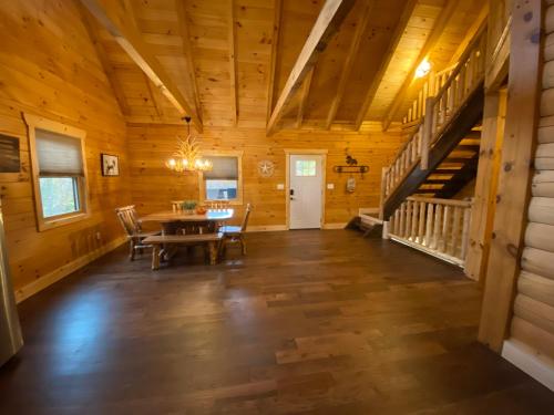 a large room with a table and stairs in a cabin at Pine Creek Cabins & Camping Resort in South Bloomingville