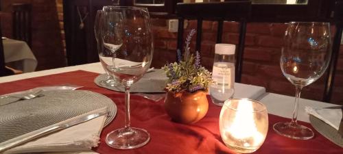 a table with three wine glasses on a red table cloth at hotel le Massilia in Belém