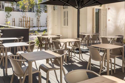 a group of tables and chairs with an umbrella at Holiday Inn Express - Lisbon - Plaza Saldanha by IHG in Lisbon