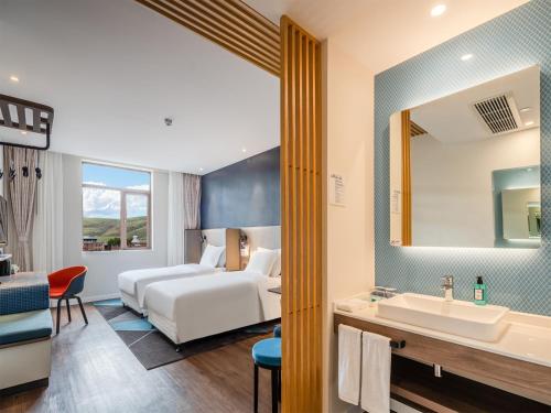 a hotel room with a bed and a sink at Holiday Inn Express Litang by IHG in Lithang