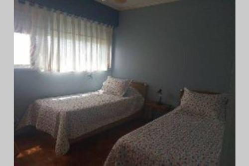 a bedroom with two beds and a window at Edificio Céntrico. in Colonia del Sacramento