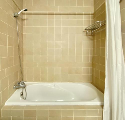a white bath tub in a bathroom with a shower at Sea Gardens - Alvaflor - Vilamoura in Vilamoura