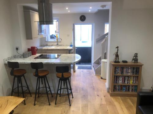 a kitchen with a island with bar stools in it at Rhos St Retreat in Ruthin