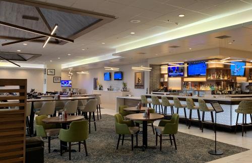 a restaurant with tables and chairs and a bar at Holiday Inn Portland - Columbia Riverfront, an IHG Hotel in Portland