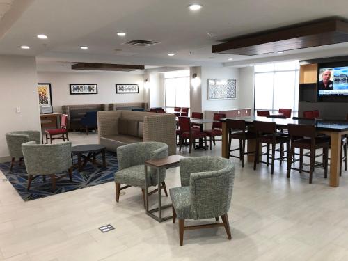 ein Wartezimmer mit Tischen und Stühlen und einem TV in der Unterkunft Holiday Inn Express Hillsboro I-35 by IHG in Hillsboro
