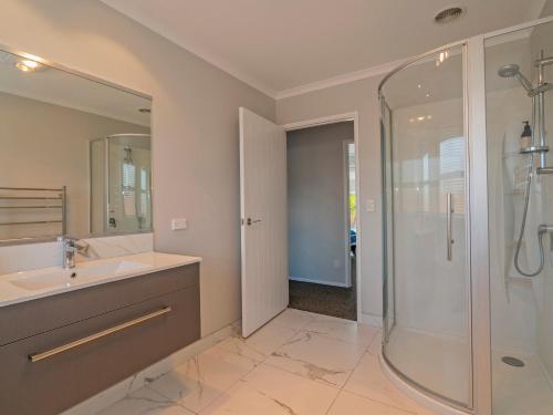 a bathroom with a sink and a shower at Modern Beach Pad - Whitianga Holiday Home in Whitianga