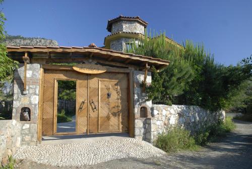 a building with a large wooden door on a stone wall at Mandarin & Mango Boutique Hotel in Faralya