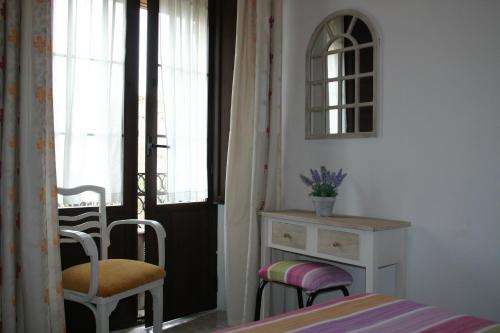 1 dormitorio con 1 cama, 2 sillas y vestidor en Pension el Portillo, en Córdoba