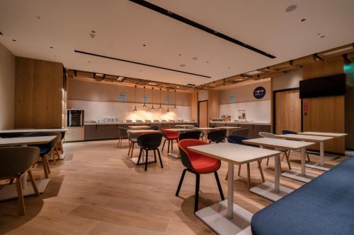 a restaurant with tables and chairs and a kitchen at Holiday Inn Express Chiayi by IHG in Chiayi City