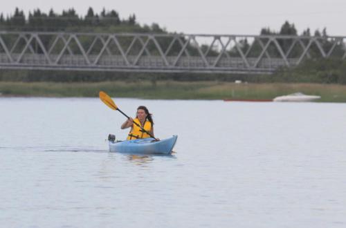 a woman in a kayak on a lake with at Deer Lake Horizon Hotel in Deer Lake