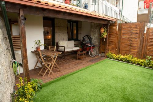 a patio with a table and a green lawn at Casa do Arco in Amarante
