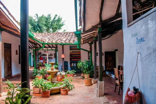 a courtyard with potted plants in a building at Nacuma Garden Hostel - Casa Nacuma in Barichara