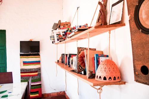 a room with wooden shelves on the wall with books at Nacuma Garden Hostel - Casa Nacuma in Barichara