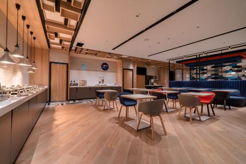 a restaurant with tables and chairs and a bar at Holiday Inn Express Chiayi by IHG in Chiayi City