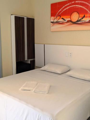 a white bed with two white towels on it at Capuchins Hotel in Porto Seguro