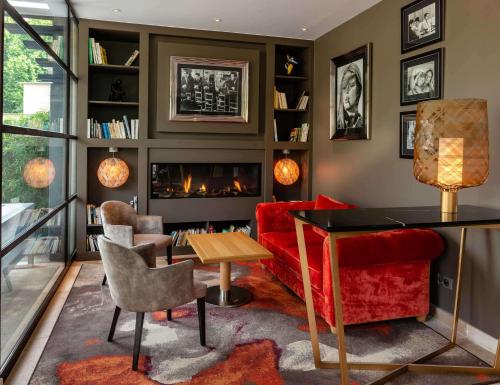 a living room with a red couch and a fireplace at Best Western Plus Le Lavarin in Avignon