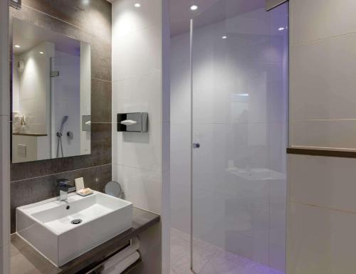 a bathroom with a sink and a glass shower at Best Western Plus Le Lavarin in Avignon