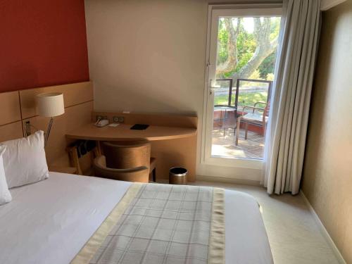 a bedroom with a bed and a door to a balcony at Best Western Plus Le Lavarin in Avignon