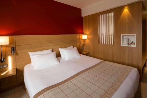 a large white bed in a hotel room at Best Western Plus Le Lavarin in Avignon