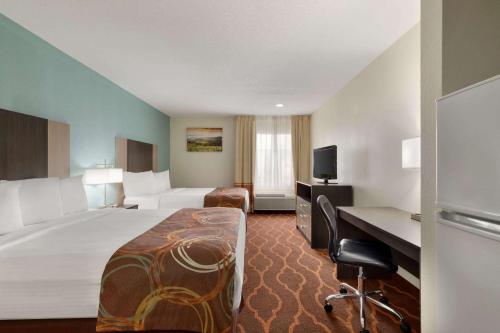 Pokój hotelowy z dużym łóżkiem i biurkiem w obiekcie Baymont by Wyndham Grovetown Augusta w mieście Augusta
