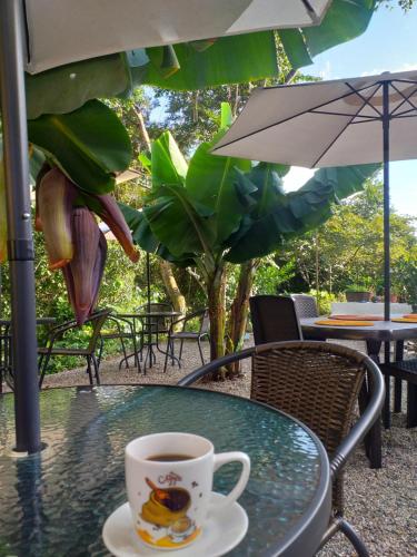 a cup of coffee sitting on a table under an umbrella at Casona CHARA in Barichara