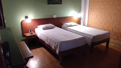 a hotel room with two beds and a lamp at hotel le Massilia in Belém