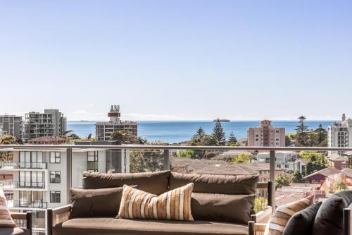 a living room with a couch and a view of the ocean at Argo Apartments in Wollongong