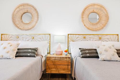 two beds in a bedroom with two mirrors on the wall at Casa del Mar in Point Pleasant Beach