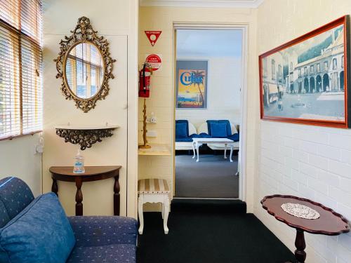 a living room with a blue couch and a table at The Mews Motel in Launceston