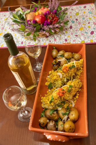 a table with a plate of food and a bottle of wine at O Palheiro - Vista Panorâmica e Jacuzzi in Sobreira Formosa