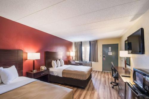 a hotel room with two beds and a flat screen tv at Econo Lodge Kearney - Liberty in Kearney